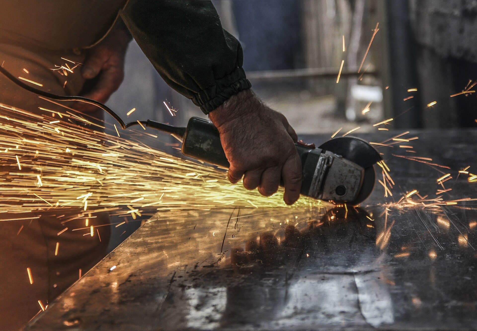 Angle grinder throwing sparks while cutting metal