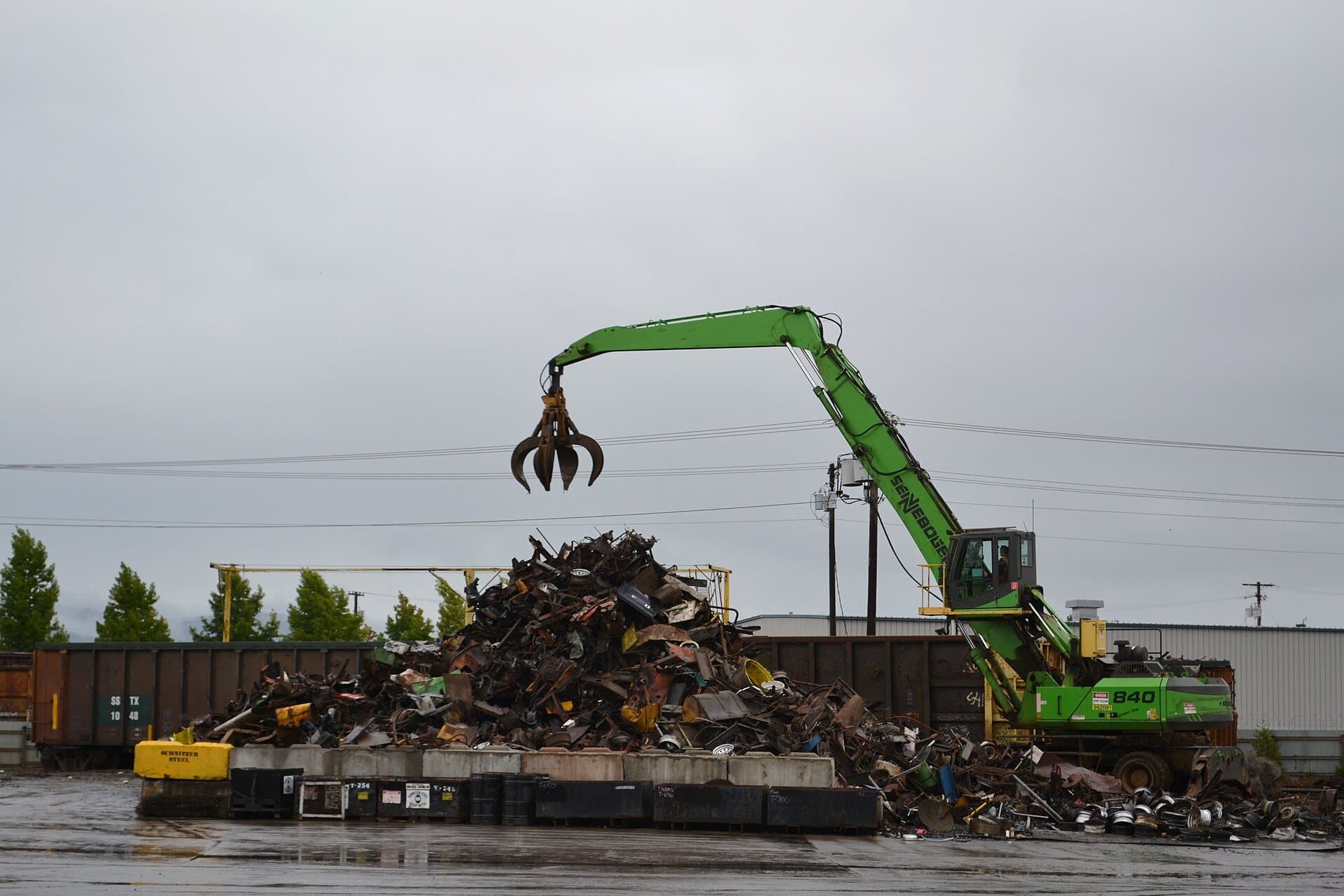 Material handler loading scrap metal at a recycling yard