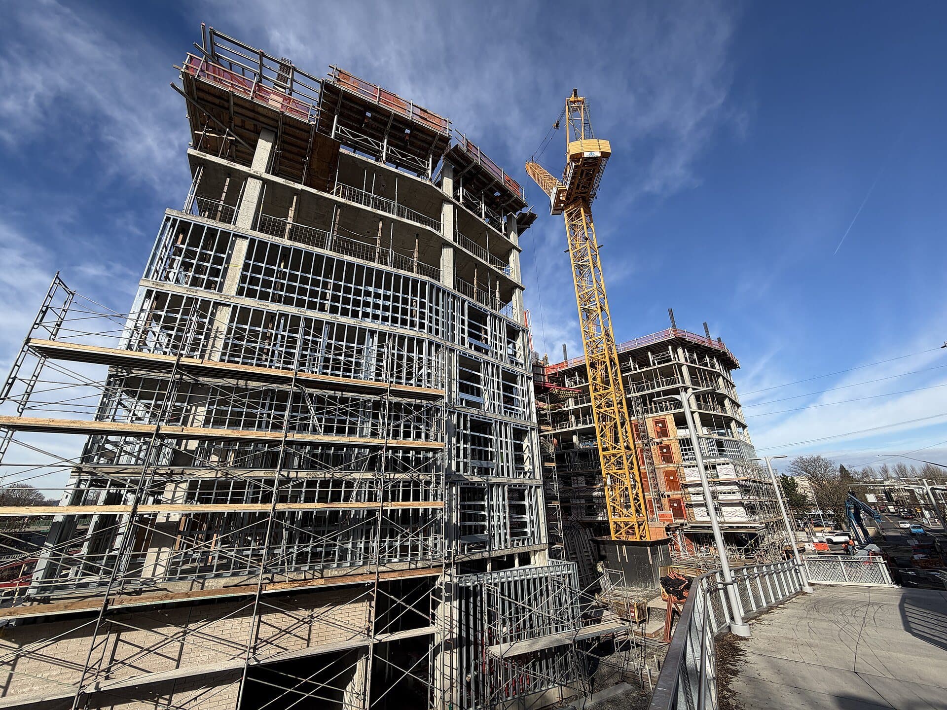 Building under construction with light gauge steel framing and cranes